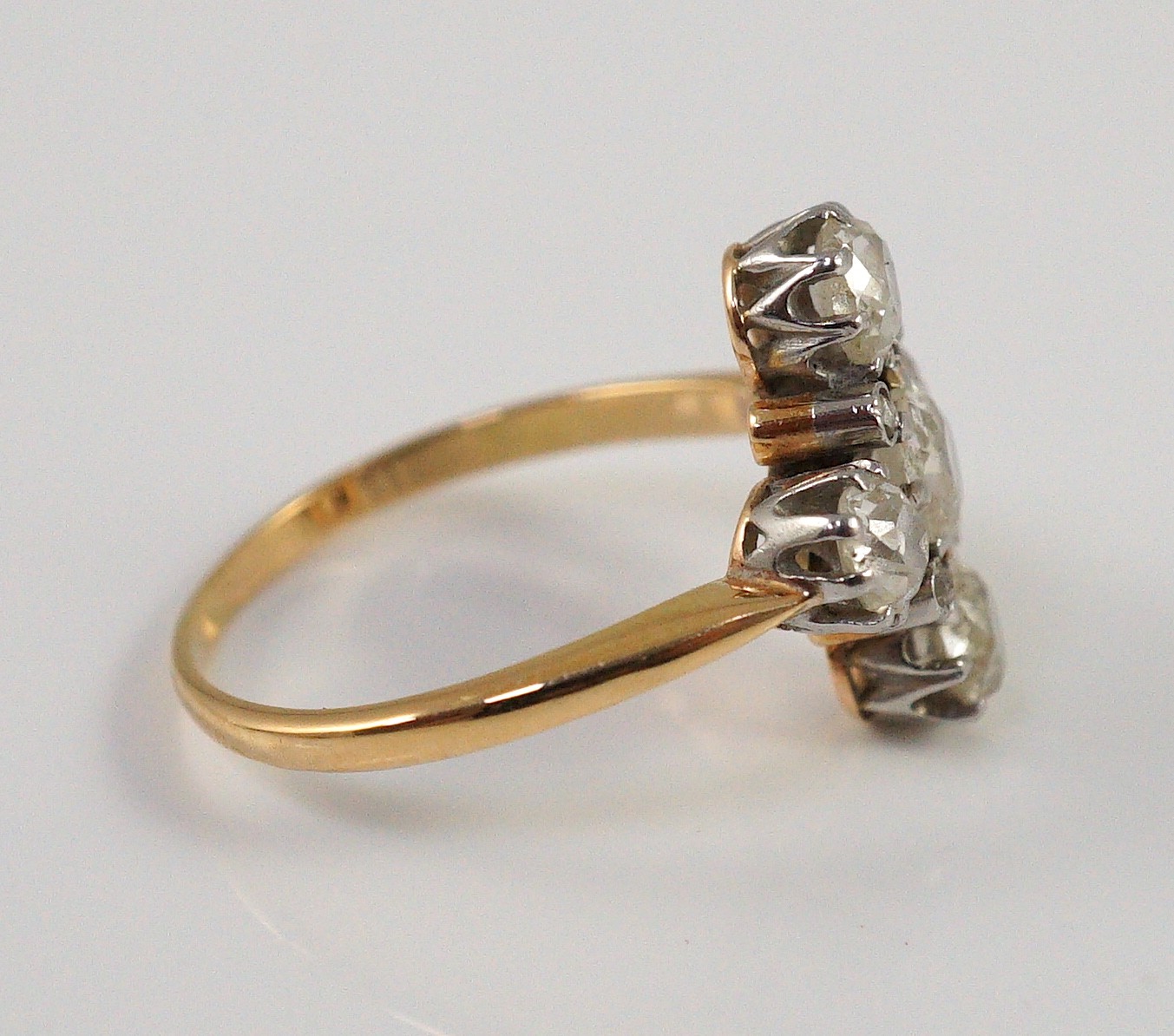 A gold and old cut five stone diamond set 'cross' ring, with diamond chip set spacers
